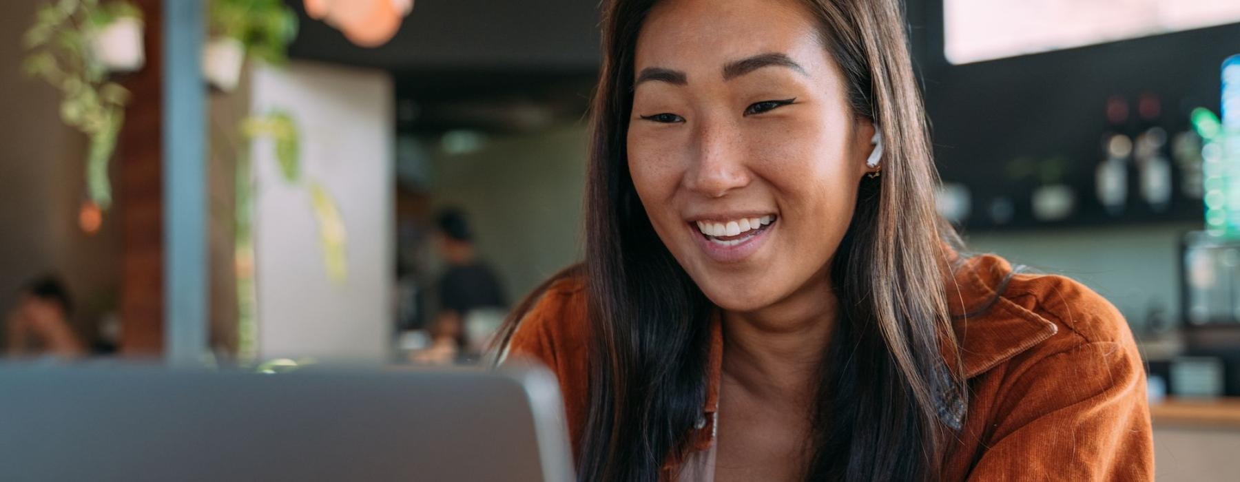 a woman smiling while working on laptop